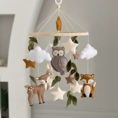 a mobile with animals and stars hanging from it's sides in a nursery room