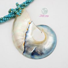 a necklace with a shell and turquoise beads