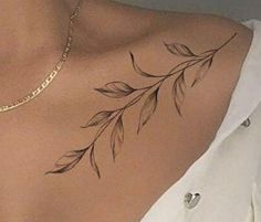 a woman's chest with leaves tattoo on the back of her neck and shoulder