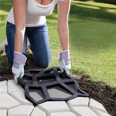 a woman in white shirt and blue jeans laying on ground next to black and white tile