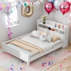 a white bed with balloons and confetti on the wall in a child's bedroom