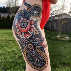 a woman's thigh with an intricate tattoo design on her leg and the legs