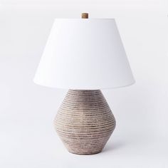 a table lamp with a white shade on it's base and a brown stripe design