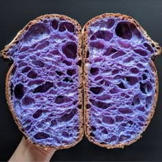 a hand holding an open purple piece of bread