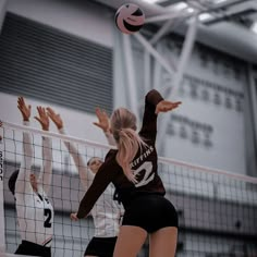 the volleyball players are playing volley ball on the court