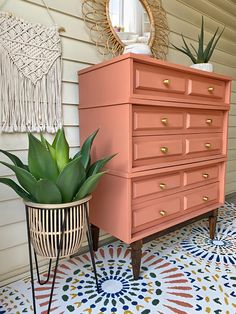 an orange dresser next to a potted plant