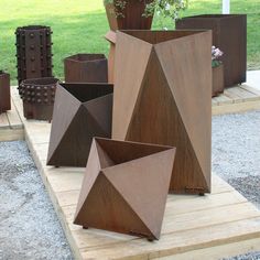 several brown vases sitting on top of a wooden platform next to a potted plant