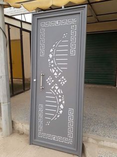 a large metal door with an intricate design on the front and side panels in grey