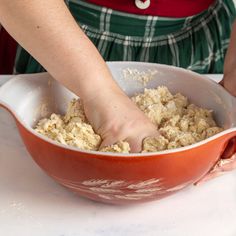 a person is mixing food in a red bowl