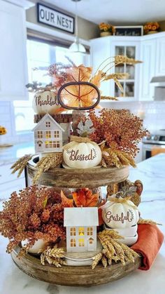 a three tiered tray filled with fall decorations