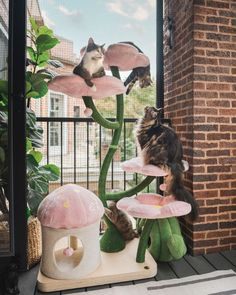 a cat sitting on top of a mushroom plant with two cats in it's back