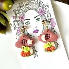 a pair of earrings with an image of a woman on the front and back of it