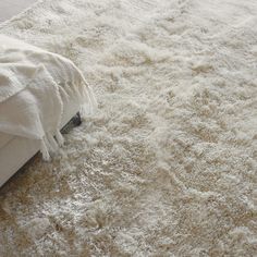 a white rug on the floor next to a bed