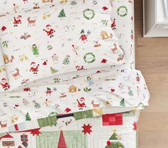 a bed covered in christmas themed sheets and pillows