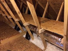 an attic filled with wooden beams and insulation