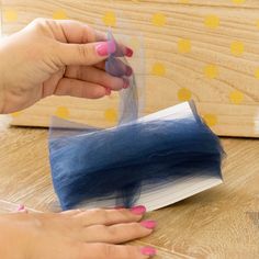 a woman is making something out of an open book on the table with her hands