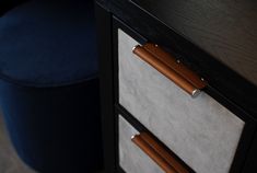 a close up of a drawer on a desk with a blue chair in the background