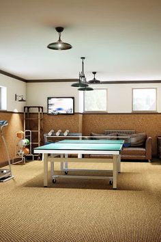 a living room filled with furniture and a ping pong table in front of a flat screen tv