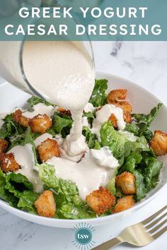 a person pouring dressing into a salad in a bowl