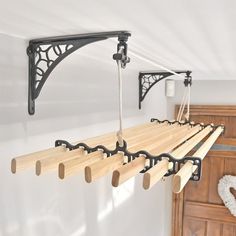 a rack with wooden clothes hanging from it's sides and hooks on the wall