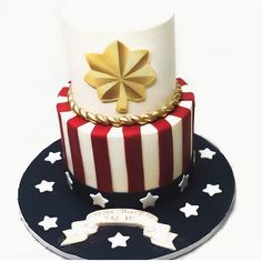 a three tiered cake with stars and stripes on the bottom, topped with a gold bow