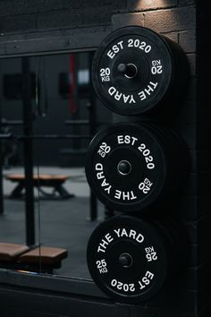 the barbell plates are hanging on the wall