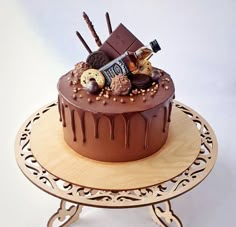 a chocolate cake sitting on top of a wooden stand with assorted candy and candies