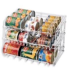 canned food is stored in a rack on the side of a white wall - mounted shelf