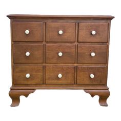 a wooden dresser with white knobs on the top and bottom drawers, against a white background