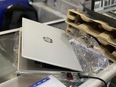 two laptops sitting on top of each other in front of some boxes and wires