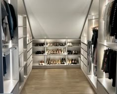 a walk in closet filled with lots of white shelves and shoes on top of them