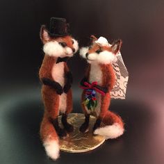 two stuffed foxes standing on top of a coin