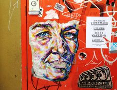 the door is covered in graffiti and has an image of a man's face on it