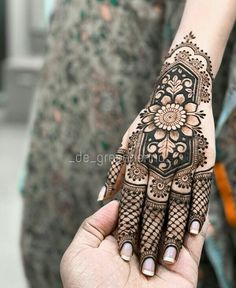 a woman's hand is decorated with hennap and flower designs on it