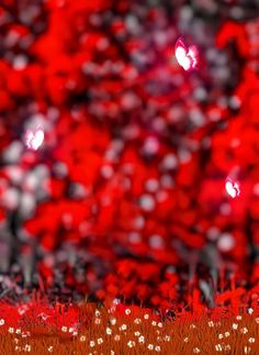 an abstract photo of red trees and grass with white dots on the ground in front of them