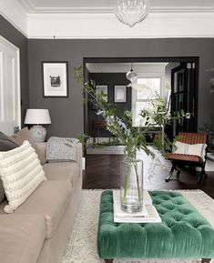 a living room filled with furniture and a large vase on top of a coffee table