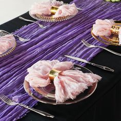 the table is set with pink flowers and silverware