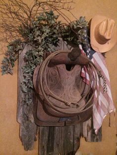 a cowboy hat hanging on the wall next to a cowgirl's purse and american flag