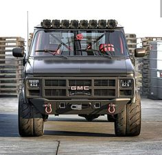 the truck is driving down the road in front of some pallet racks with crates behind it