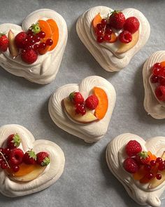 four heart shaped pastries with fruit on top are arranged in the shape of hearts