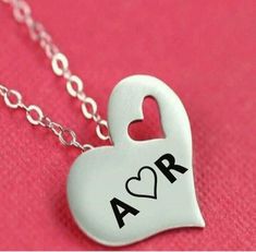 a heart shaped necklace with the word ar on it