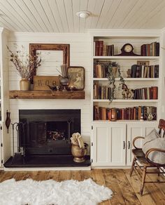 a living room filled with furniture and a fire place next to a bookshelf