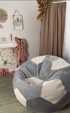 a large bean bag chair sitting on top of a wooden floor next to a window