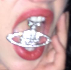 a close up of a person holding a metal object in their mouth