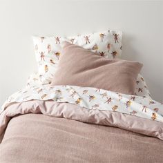 an unmade bed with pink sheets and pillows