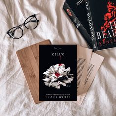 two books on a bed next to glasses and a book with the title craye