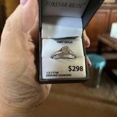 a person holding a ring in their hand with the price tag on it and an open box