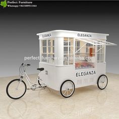 an ice cream cart with a bicycle parked next to it and the words elegance written on the side