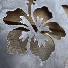 a metal flower cut out on top of a piece of wood with the word love written in it