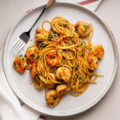 a white plate topped with pasta and shrimp